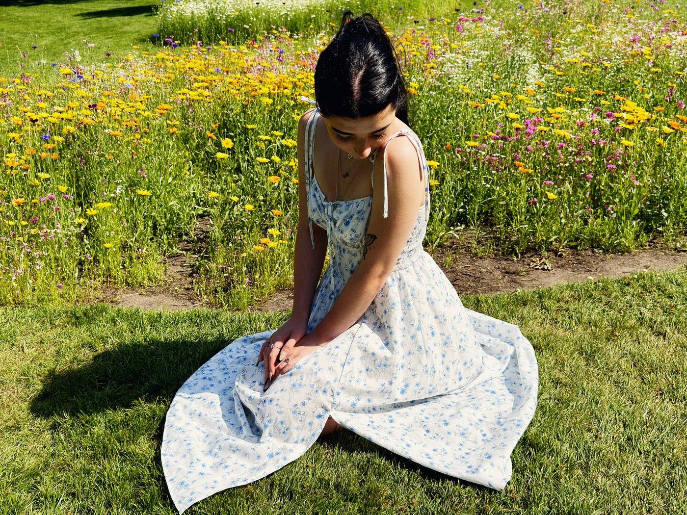 Emmy Bloom kneeling in a flower meadow